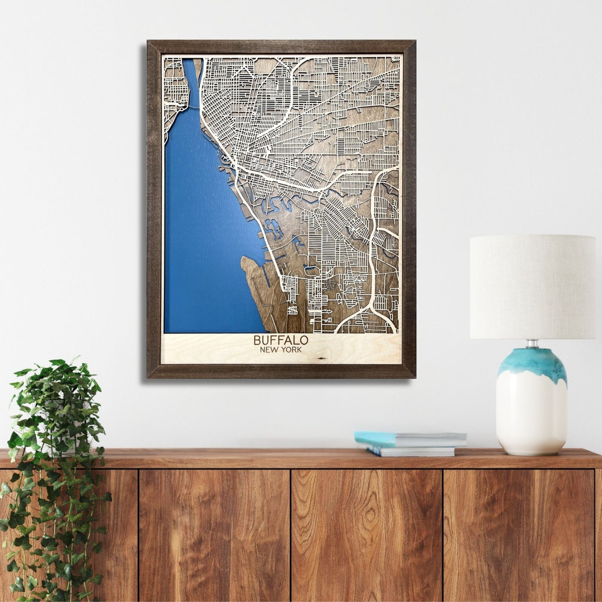 Wooden map of Buffalo, NY hanging on a wall above a console.