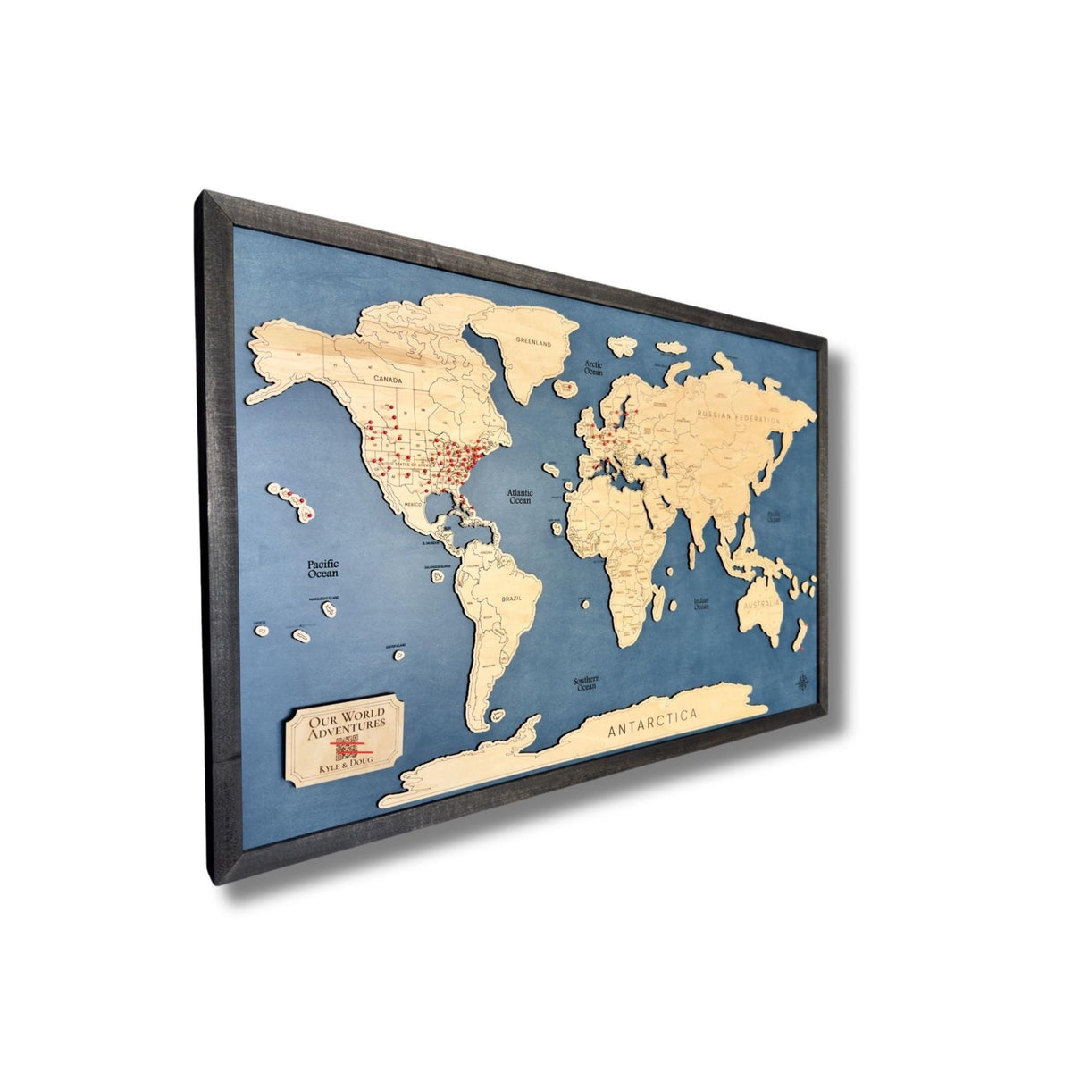 Sideview of the MapCuts' World Travel Map with a digital photo album and red pins to track your travels.