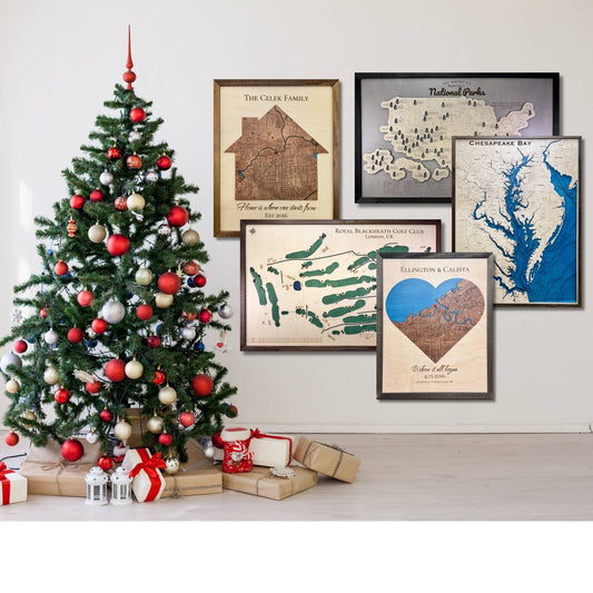 A Christmas tree with presents and 5 different wooden map examples hanging on the wall.