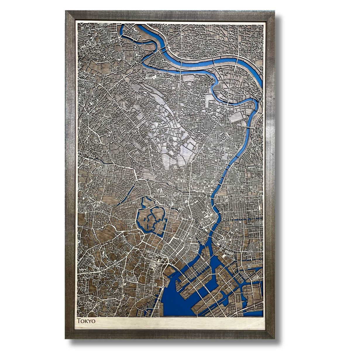 Framed wooden map of Tokyo with raised roads and recessed water layer. 