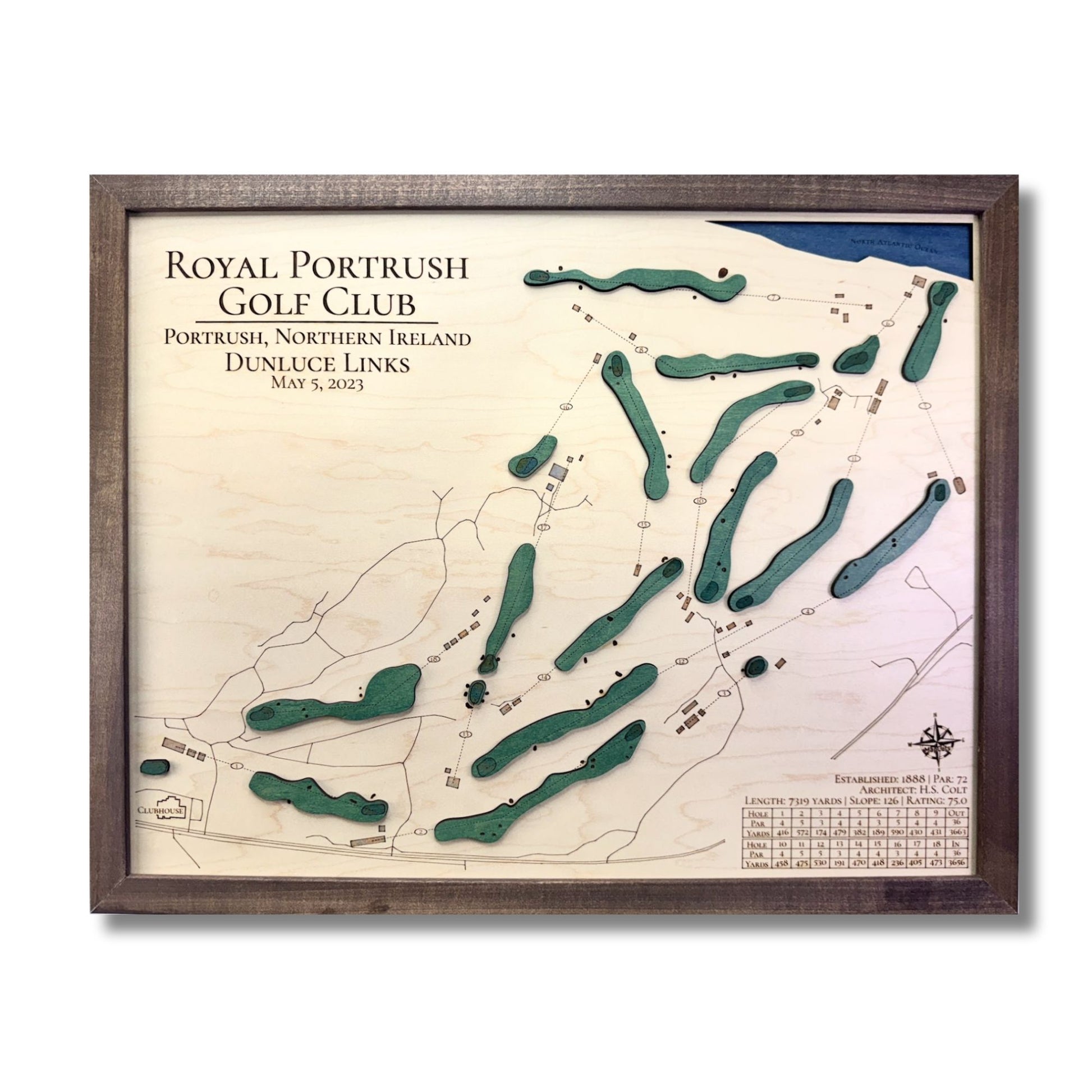 Framed map of Royal Portrush Golf Club with brown wooden frame, dark blue water stain, and raised green greens.