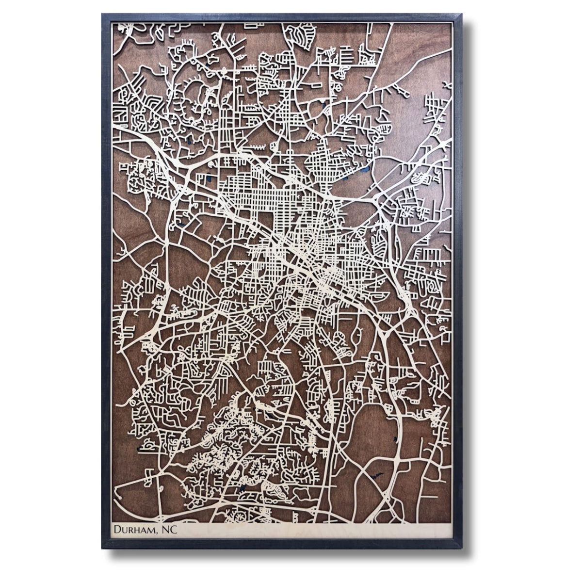 Large Durham, NC wooden map with raised light wood colored roads and a darker wood background. 