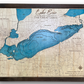 A 3D multilayer wooden map of Lake Erie with engraved roadways, cities, and state names. 