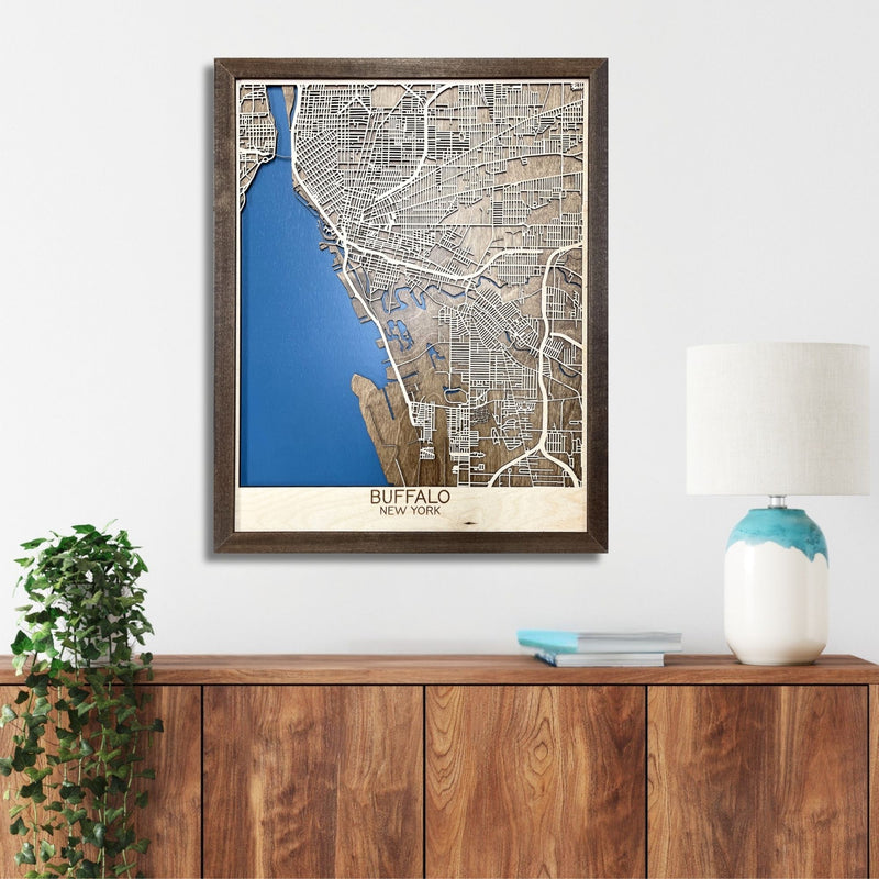 Wooden map of Buffalo, NY hanging on a wall above a console. 