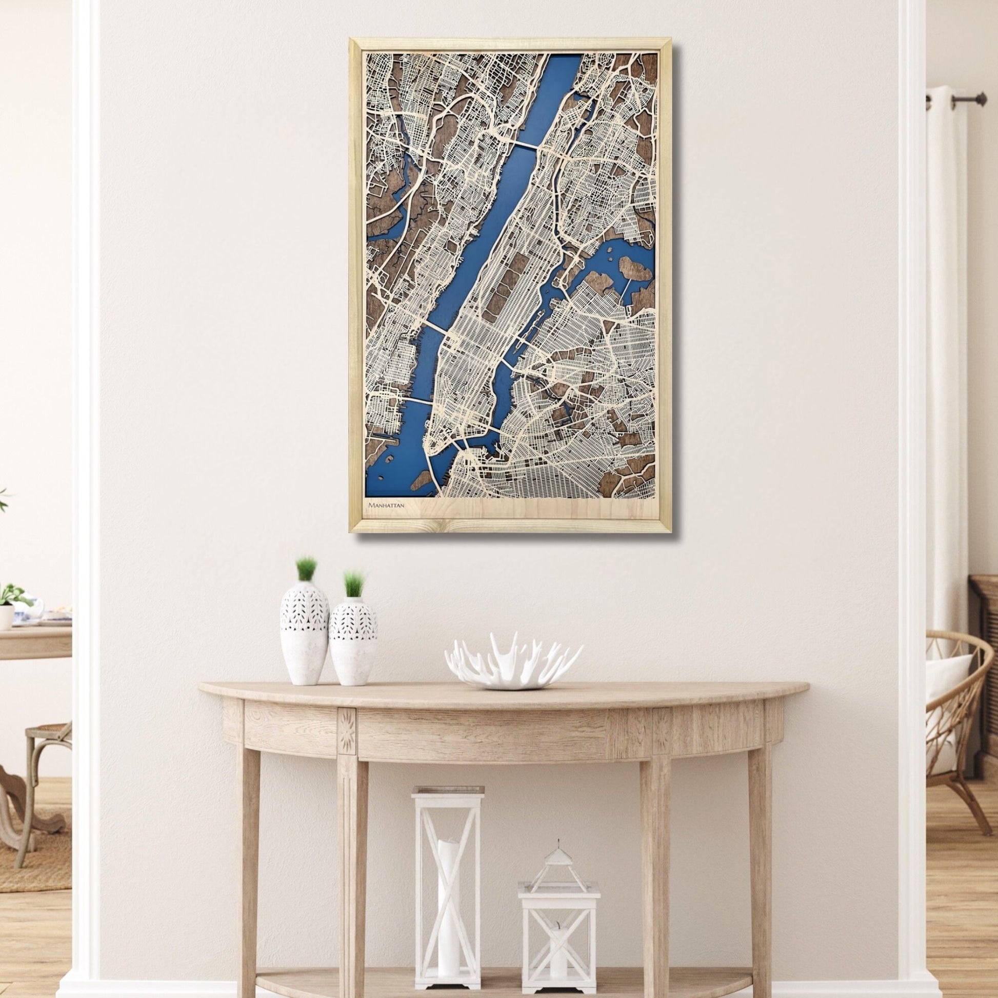 Framed wooden map of Manhattan hanging on a wall above a table. 
