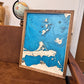 3D wooden Lake Erie Island map sitting on a couch. 