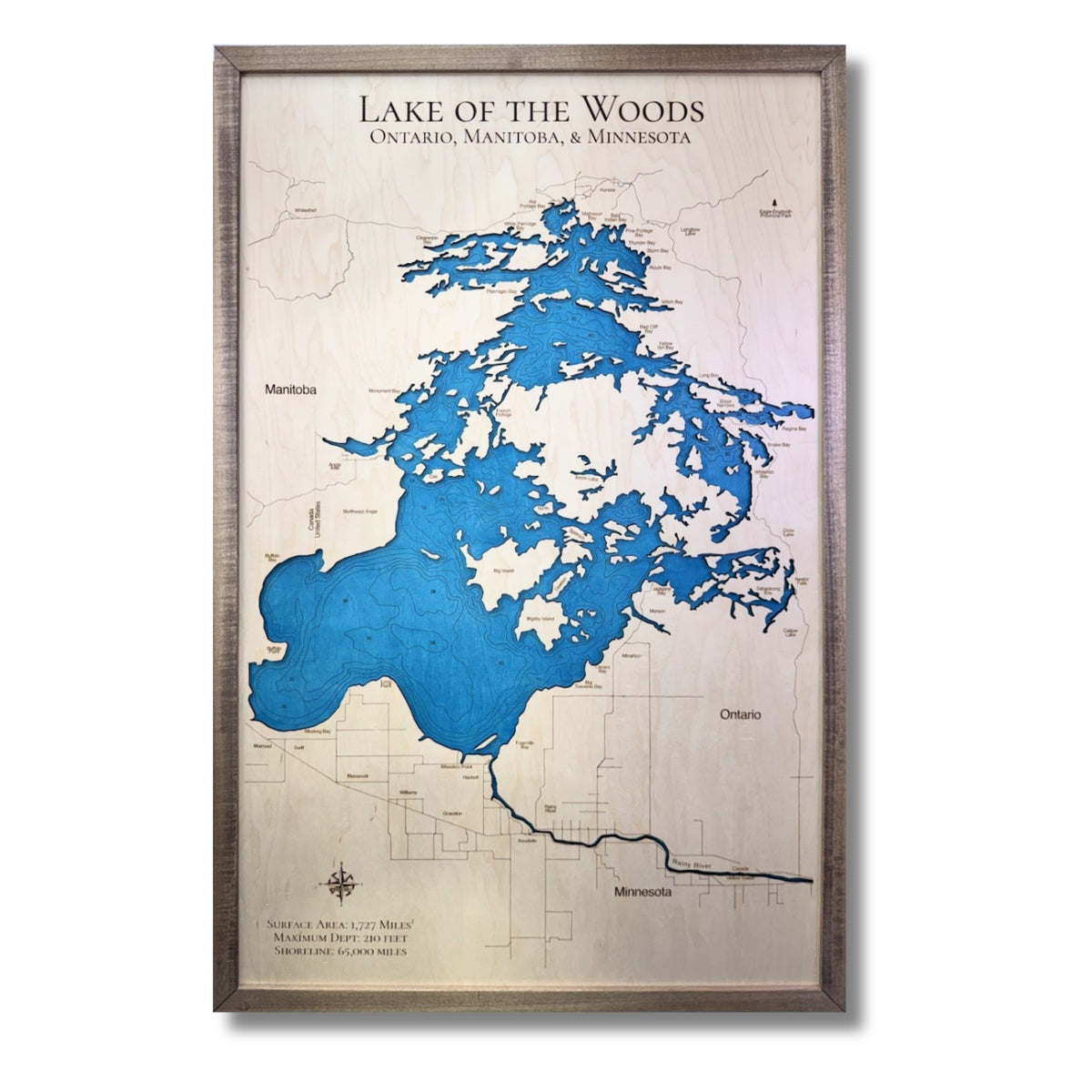 Engraved water layer map of Lake of the Woods with blue water stain and a walnut brown frame. 
