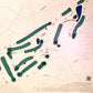 Close up of wooden golf course map with green fairways, blue water hazards, and engraved text. 