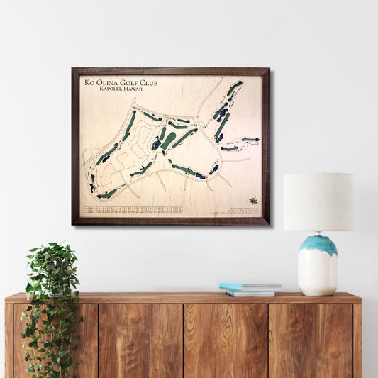 Framed golf course map on a wall above a wooden console table with decor items.