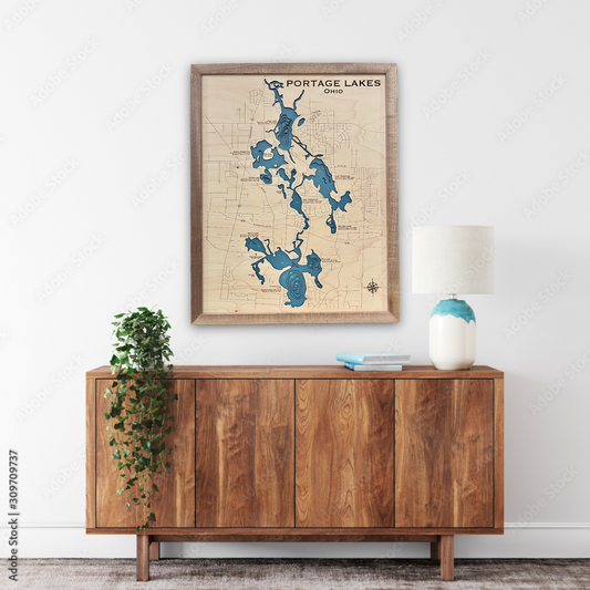 A large wooden map of Portage Lakes, Ohio hanging on a wall over a cabinet in a living room. 