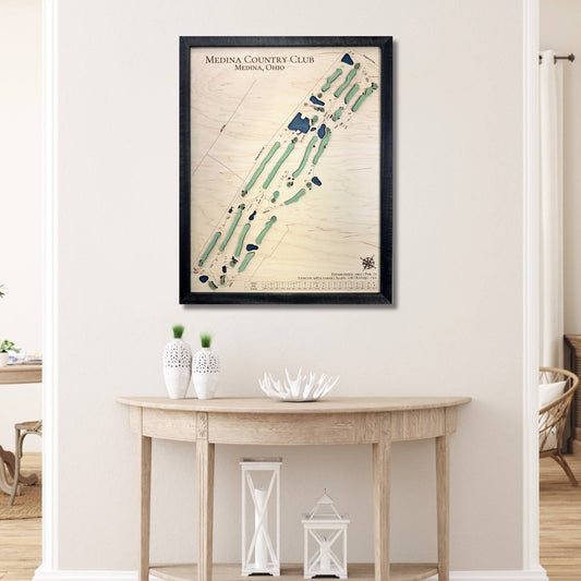 Framed wooden map of Medina Country Club on a wall above a wooden table.