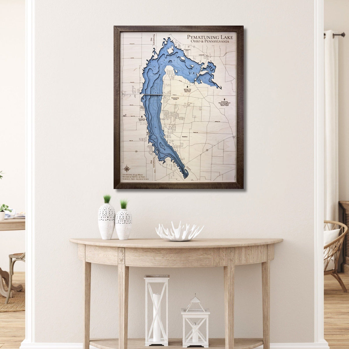 3D wood map of Pymatuning Lake hanging on a wall over a table. 