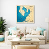 Framed wooden map of Tampa Bay on a wall above a living room sofa with decorative pillows.