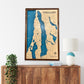 Wooden map of Torch Lake hanging on the wall above a dresser. 