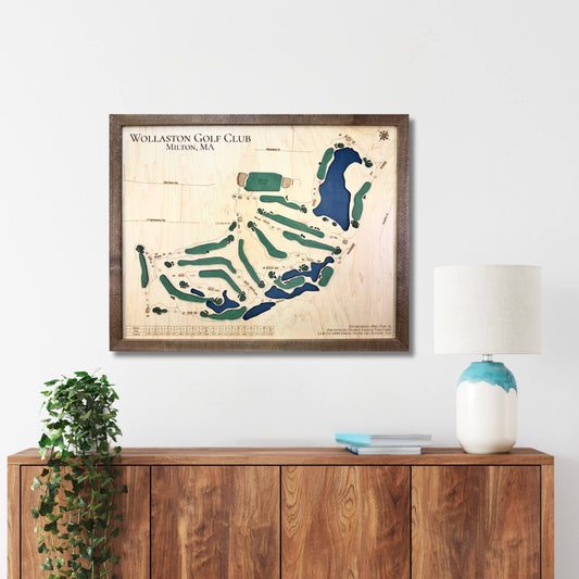 Framed map of Wollaston Golf Club on a wall above a wooden console table.