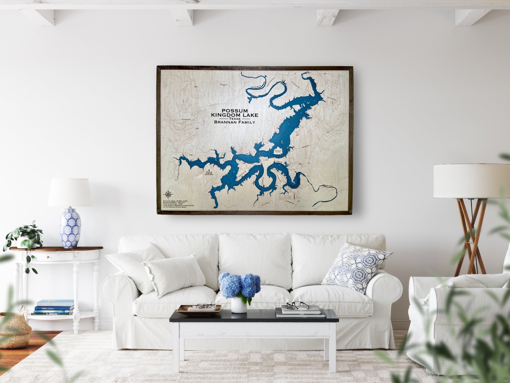 Custom wooden Lake Map of Possum Kingdom lake in Texas hanging on a wall above a couch. 
