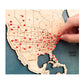 Close up of hand putting red pin in a travel location in the USA.