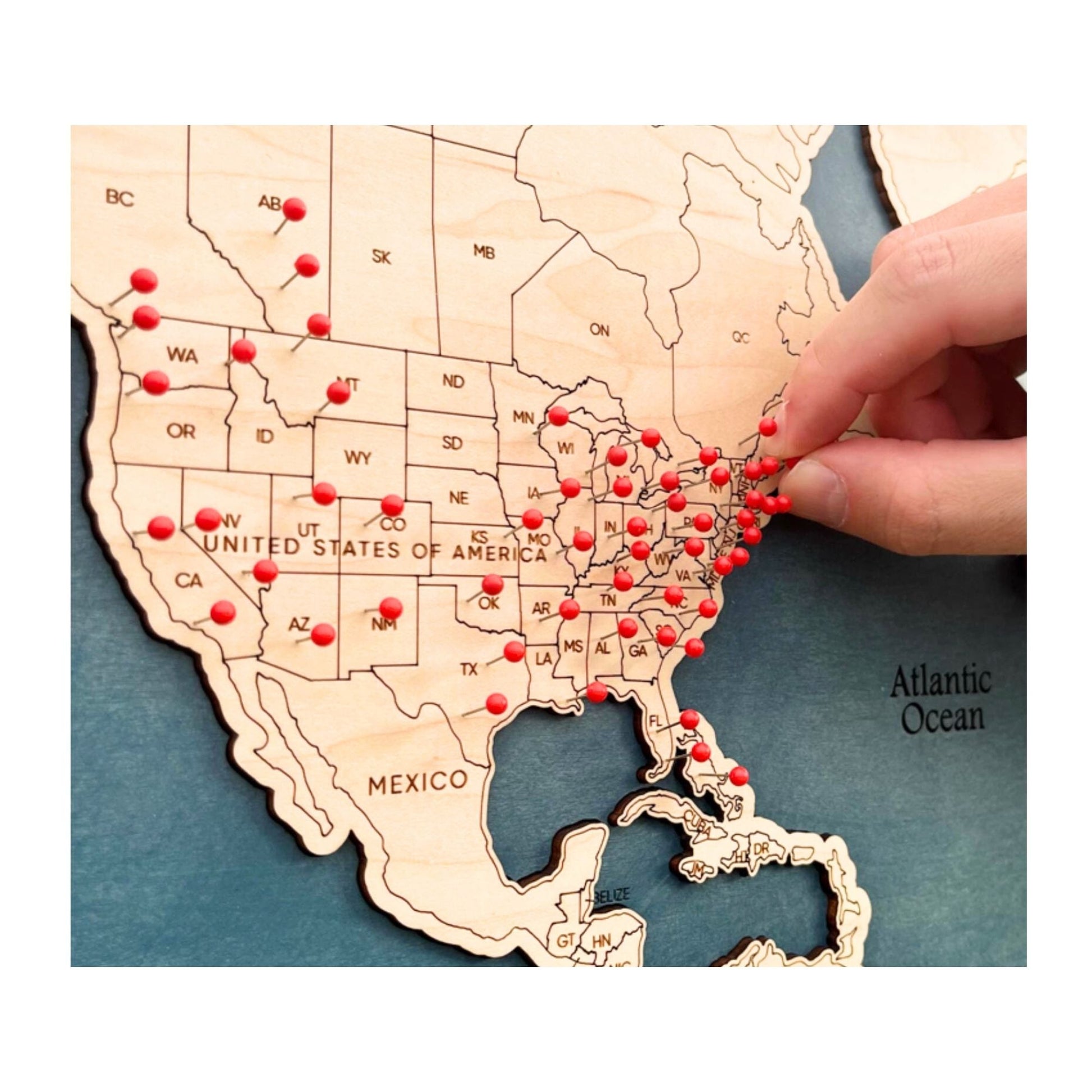 Close up of hand putting red pin in a travel location in the USA.