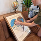 A woman is placing a red heart icon on a two-toned heart-shaped map.