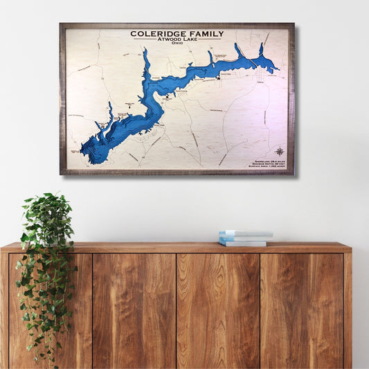 Framed map of Lake Atwood with personalized text above a wooden cabinet.