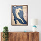 Multi water layer map of Camano Island hanging on a wall above a cabinet. 