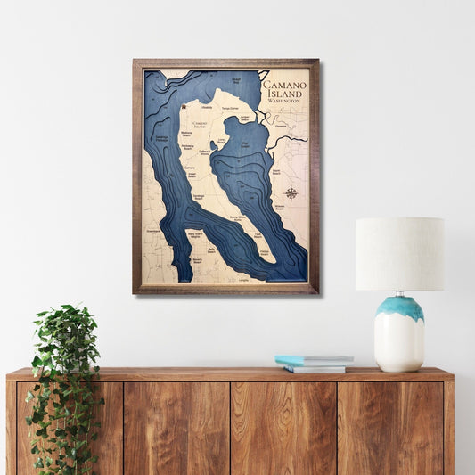 Multi water layer map of Camano Island hanging on a wall above a cabinet. 
