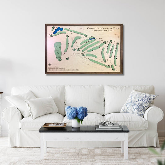Framed wooden golf course map above a white sofa in a living room.