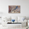 Framed wooden city map of Chattanooga, TN hanging on a living room wall above a sofa. 