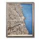 A wooden city map of Chicago with dark blue water stain and beige raised roads.
