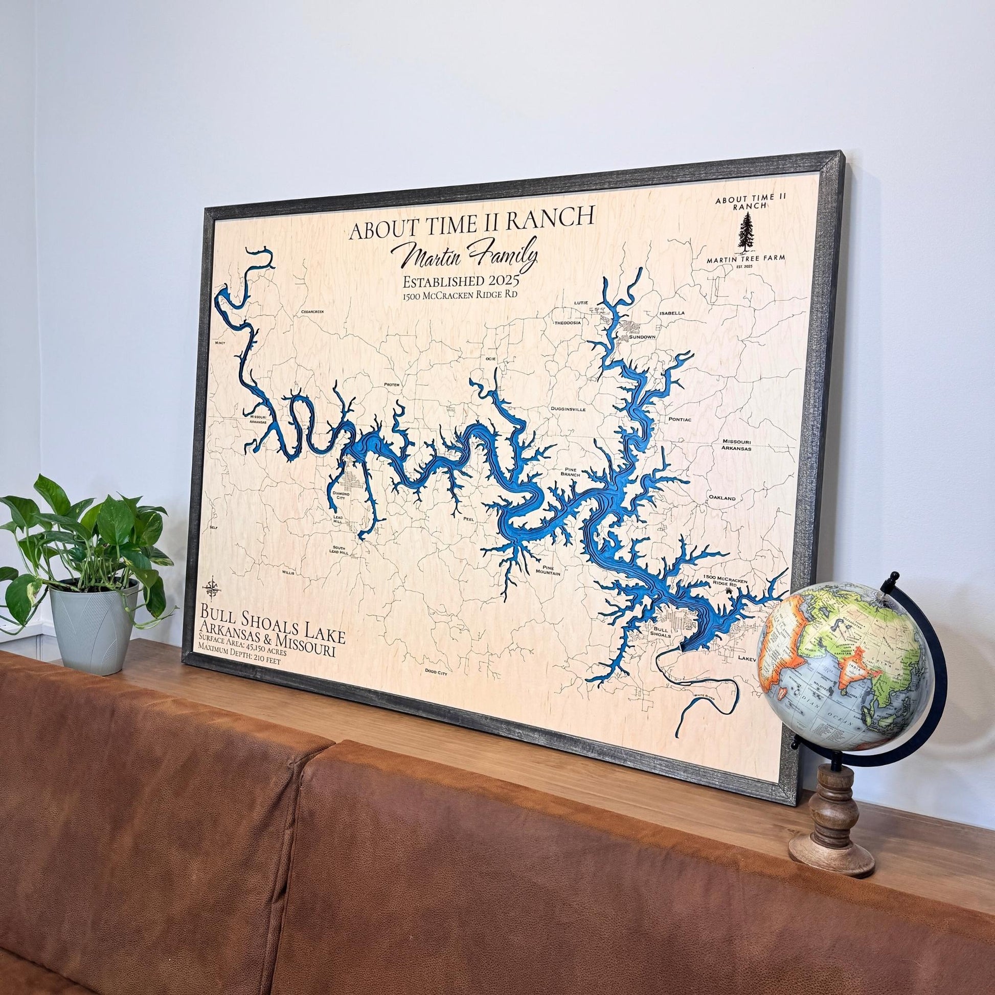 Framed wooden map of Bull Shoals Lake propped against a wall above a couch. 