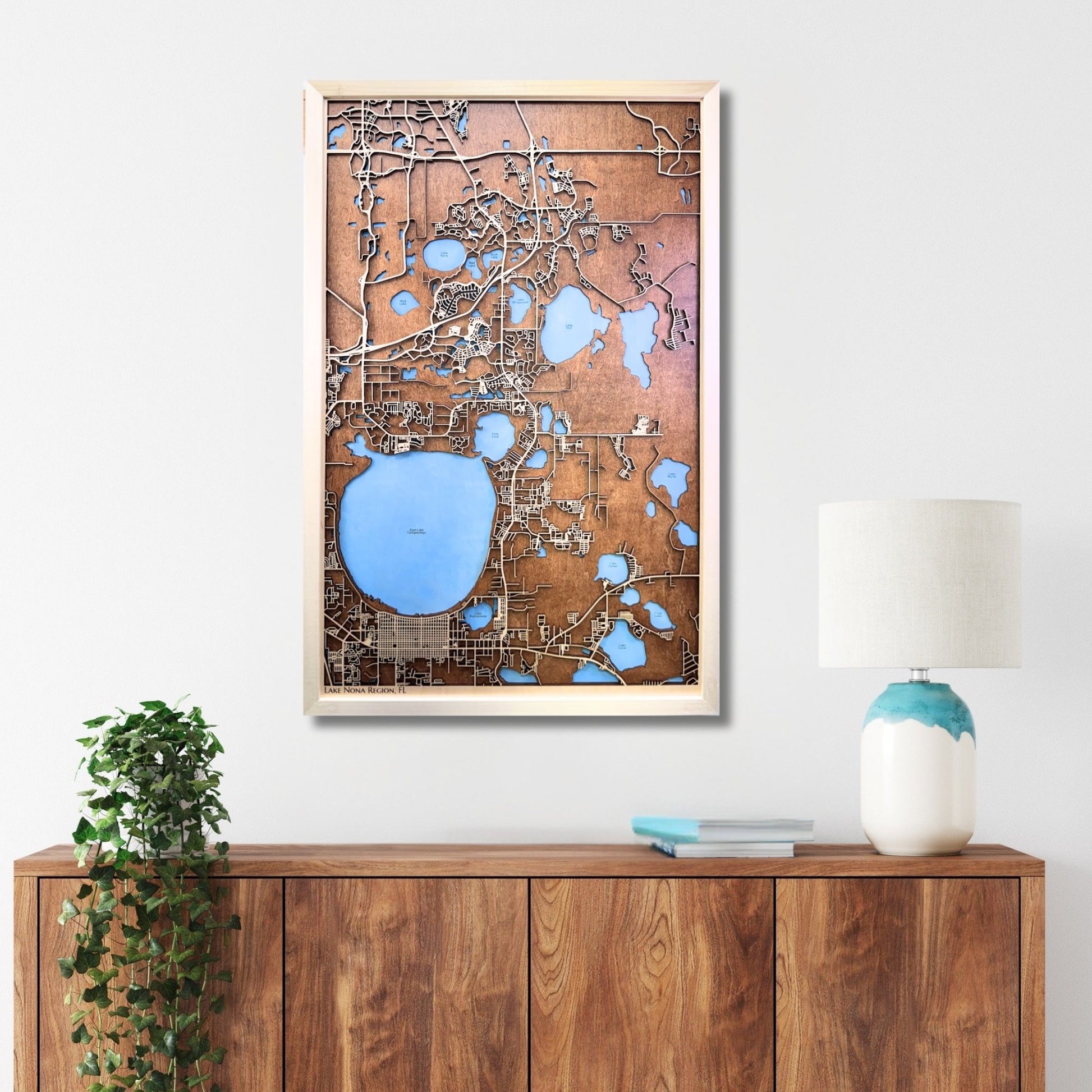 Custom wooden city map hanging on wall above a console. 