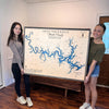 Two women holding a large custom wooden map of Bull Shoals Lake.