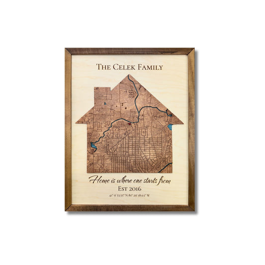 A 3D wooden map in the shape of a house with personalized title, quote, established date, and coordinates. 
