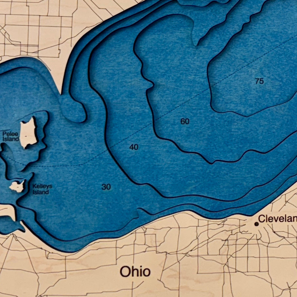 Close up image of the cut layers in the Lake Erie wooden map. 
