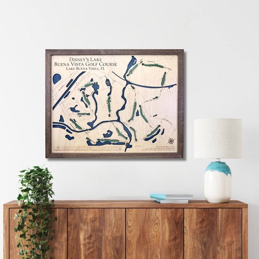 Framed wooden golf map of Disney's Lake Buena Vista Golf Course on a wall above a wooden console table.