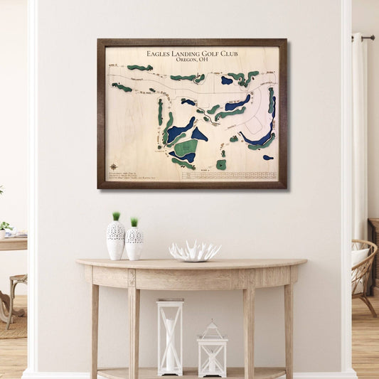 Framed golf map of Eagles Landing Golf Club on a wall above a wooden table.