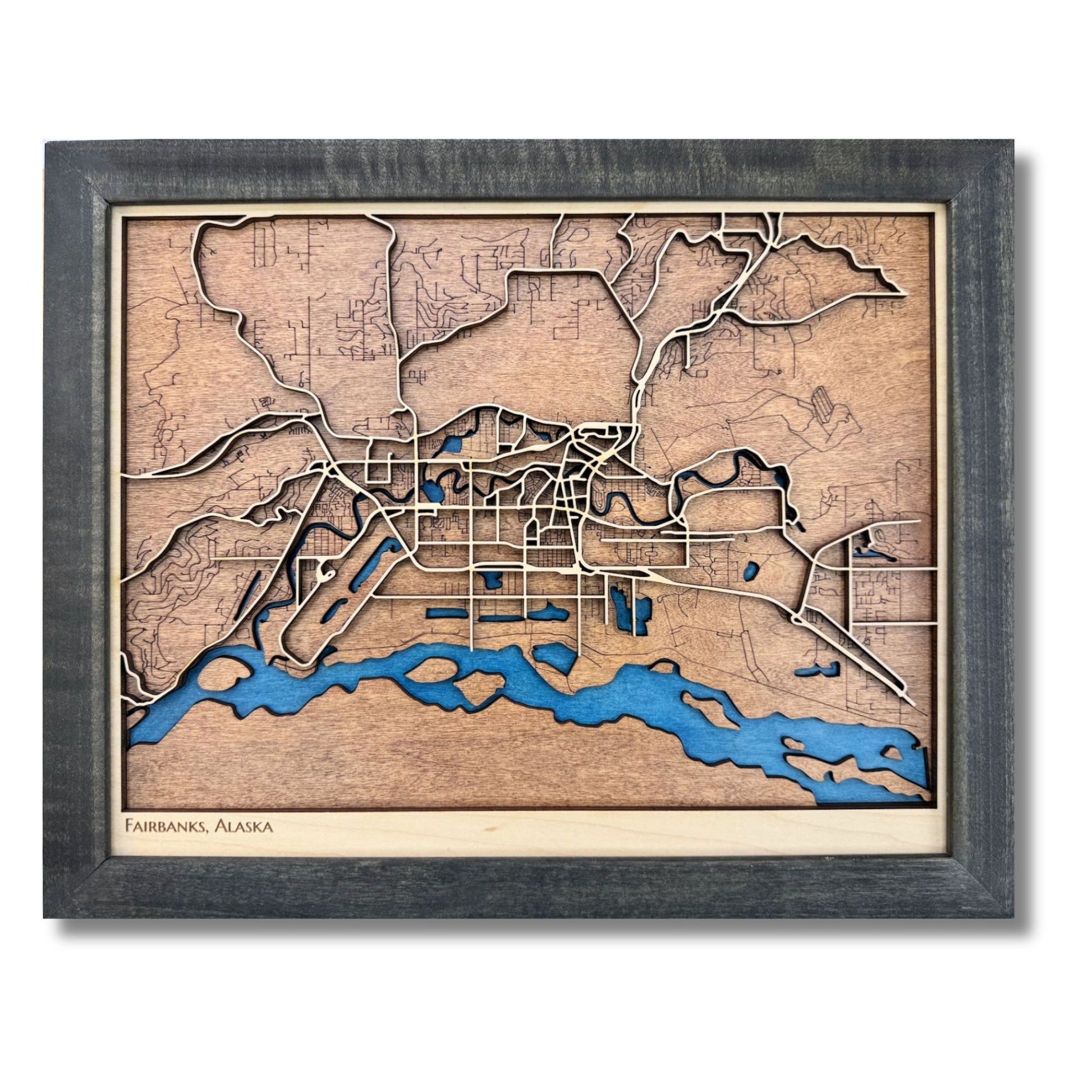 3D wooden map of Fairbanks, Alaska with raised and engraved roads, blue water stain, and a black frame. 