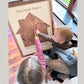 Two children and their mom pointing at the heart icon on a map. 