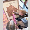 Two children and their mom pointing at the heart icon on a map. 