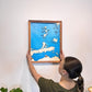 Woman hanging a Lake Erie Island map on the wall.