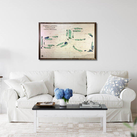 Living room with a white sofa, coffee table, and framed wooden golf map on the wall.