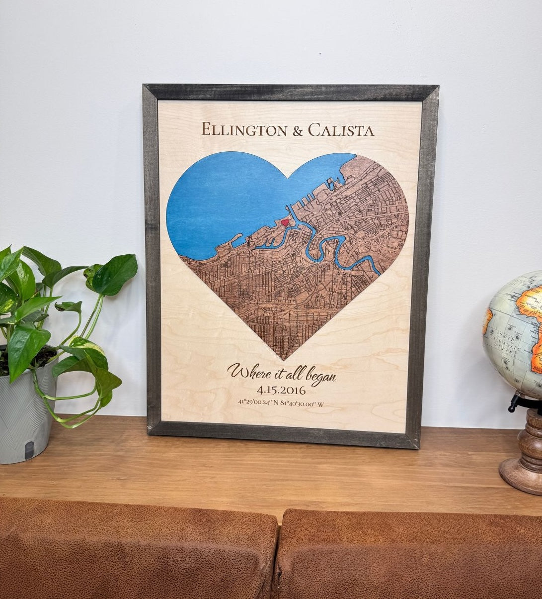 A heart-shaped wood map sits on display on a table.