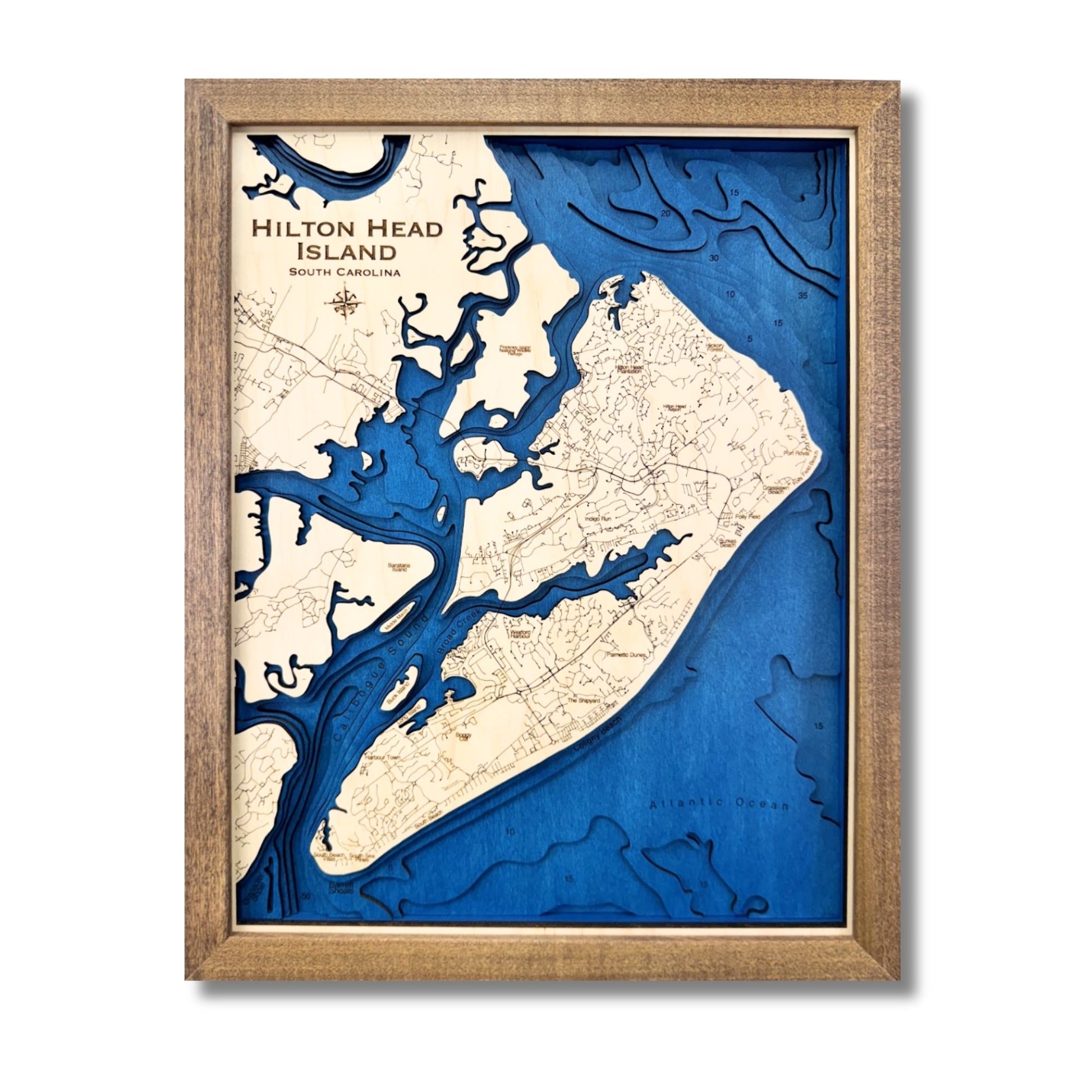 Multilayer wooden map of Hilton Head with a dark blue water stain and walnut frame. 