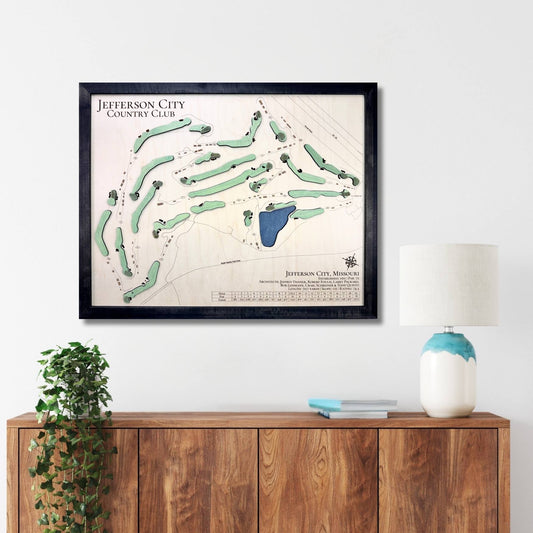 Framed wooden golf map of Jefferson City Country Club on a wall above a wooden console table.