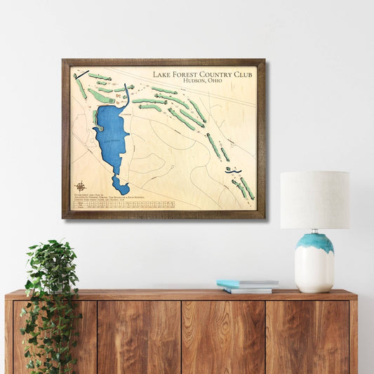 Framed wooden golf map of Lake Forest Country Club on a wall above a wooden console table.