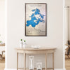 Framed wooden map of Lake of the Woods on a wall above a wooden table.