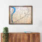 Framed topographic map of the Driftless Area on a white wall above a wooden cabinet.