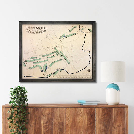 Framed wooden golf map of Lincolnshire Country Club on a wall above a wooden console table.