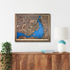 Framed wooden map of Montreal hanging on a wall above a console. 