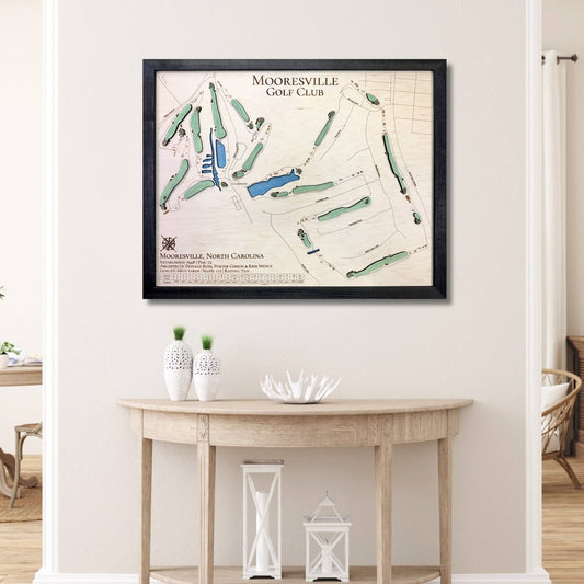 Framed 3D wooden map of Mooresville Golf Club on a wall above a wooden table.